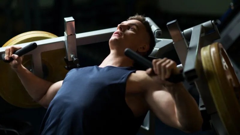 Guy working out and doing his exercises on chest-press-machine