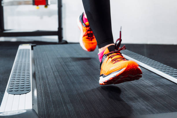 A pair of sleek, high-performance running shoes placed on a treadmill surface. The shoes feature vibrant colors and cutting-edge design, perfectly illustrating the importance of proper footwear for treadmill workouts.