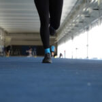 Close up of a Womans shoes and her Running on a running lane